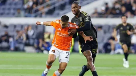 Ondrej Lingr #9 of Houston Dynamo FC gets fouled by Nkosi Tafari #91 of LAFC during an MLS match against LAFC on May 10, 2026 at BMO Stadium in Los Angeles, California.